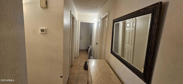 hall with light tile patterned floors and a textured ceiling