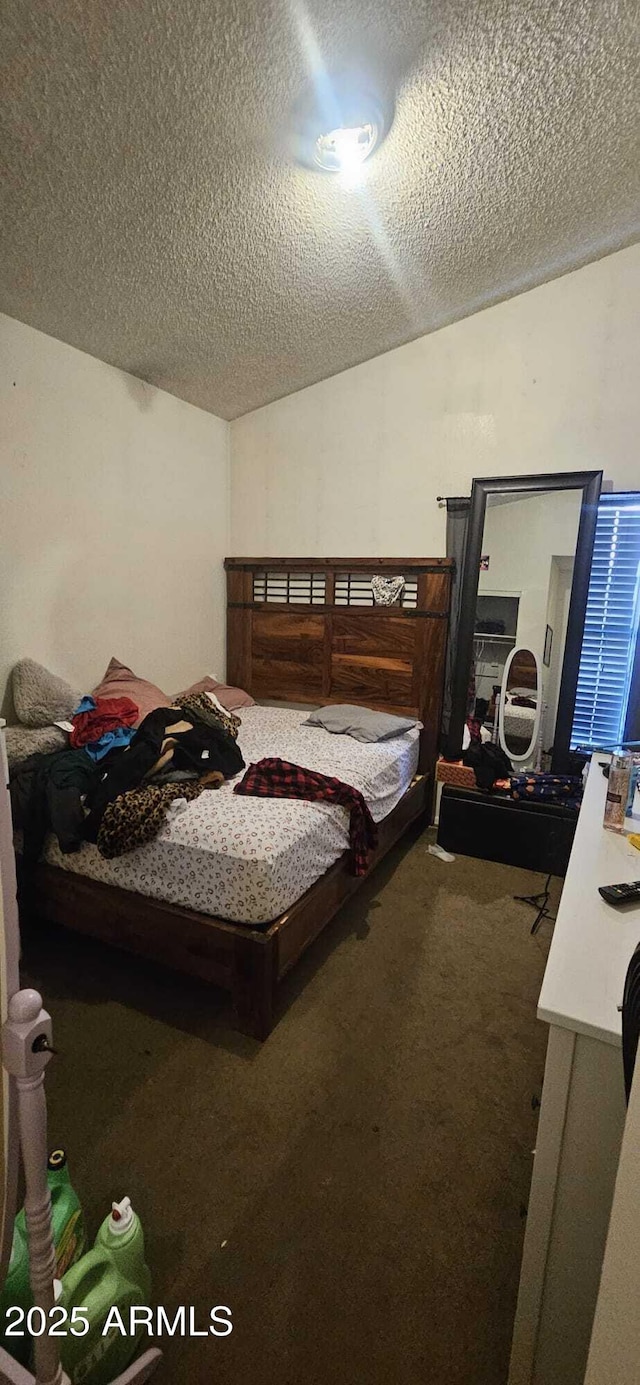 bedroom featuring carpet, lofted ceiling, and a textured ceiling