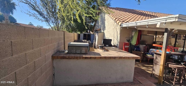 view of patio / terrace featuring area for grilling, a pergola, and exterior bar