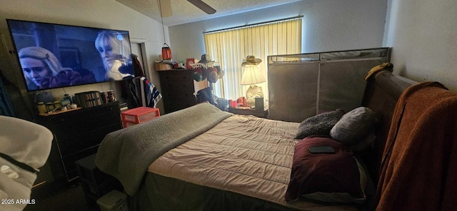 bedroom featuring ceiling fan, lofted ceiling, and a textured ceiling