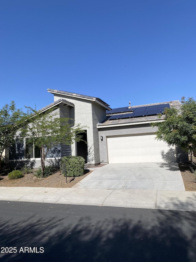 2181 N 211th Dr, Buckeye, AZ 85396 - view of front of home with concrete driveway, an attached garage, solar panels, and stucco siding