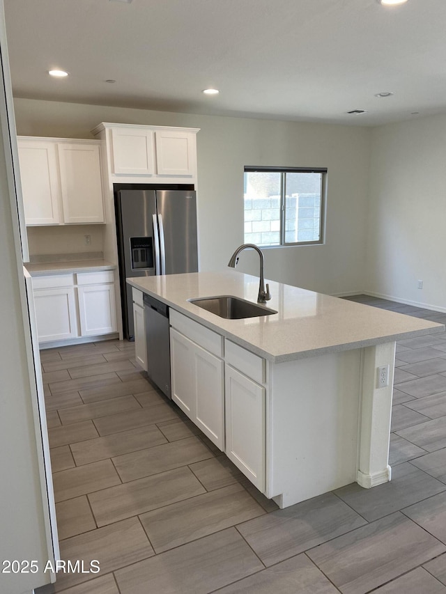 2181 N 211th Dr, Buckeye, AZ 85396 - kitchen featuring stainless steel dishwasher, a sink, light countertops, a center island with sink, and white cabinetry