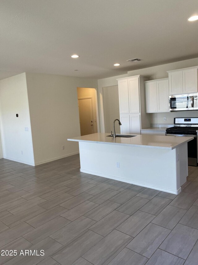 2181 N 211th Dr, Buckeye, AZ 85396 - kitchen featuring stainless steel appliances, a sink, an island with sink, recessed lighting, and light countertops
