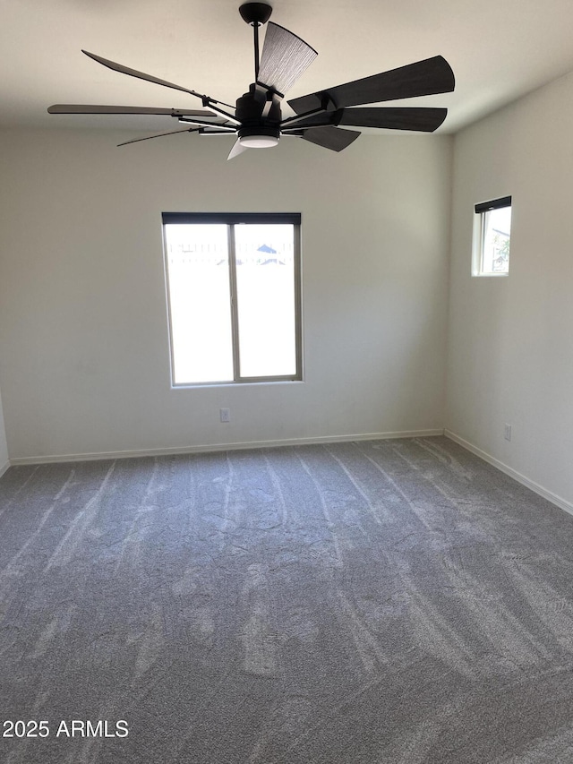2181 N 211th Dr, Buckeye, AZ 85396 - spare room featuring dark colored carpet, a ceiling fan, and baseboards
