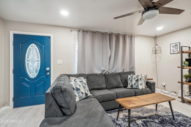 living room featuring light hardwood / wood-style flooring and ceiling fan