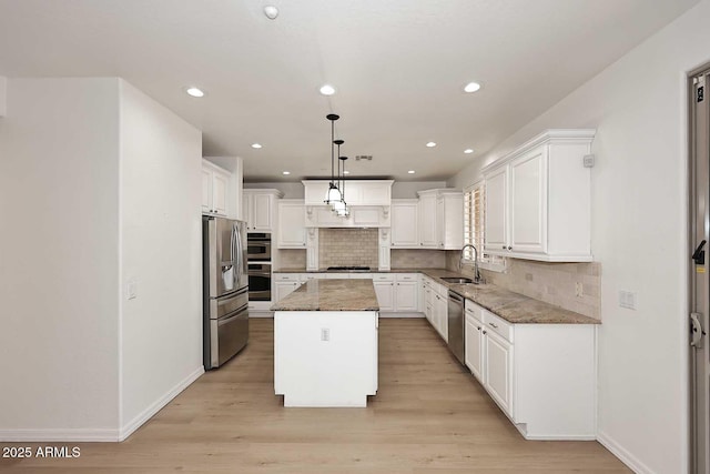 3931 E Crest Ln, Phoenix, AZ 85050 - kitchen with appliances with stainless steel finishes, a sink, a center island, white cabinets, and tasteful backsplash