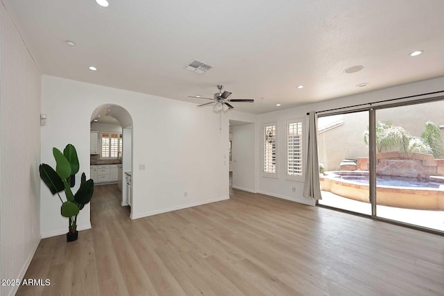 3931 E Crest Ln, Phoenix, AZ 85050 - unfurnished room with arched walkways, light wood finished floors, ceiling fan, recessed lighting, and baseboards