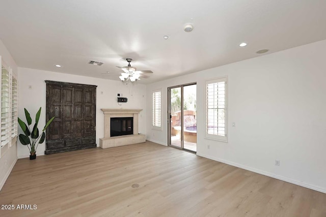 3931 E Crest Ln, Phoenix, AZ 85050 - unfurnished living room featuring a glass covered fireplace, baseboards, light wood-style floors, a ceiling fan, and recessed lighting