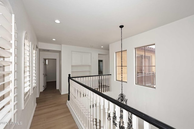 3931 E Crest Ln, Phoenix, AZ 85050 - hallway with an upstairs landing, light wood finished floors, recessed lighting, and baseboards
