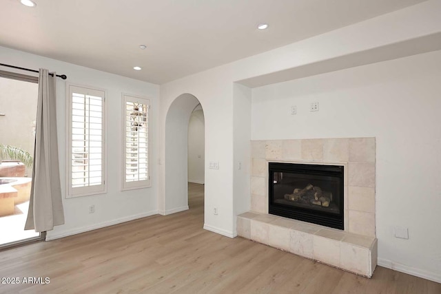 3931 E Crest Ln, Phoenix, AZ 85050 - unfurnished living room featuring wood finished floors, recessed lighting, arched walkways, baseboards, and a fireplace