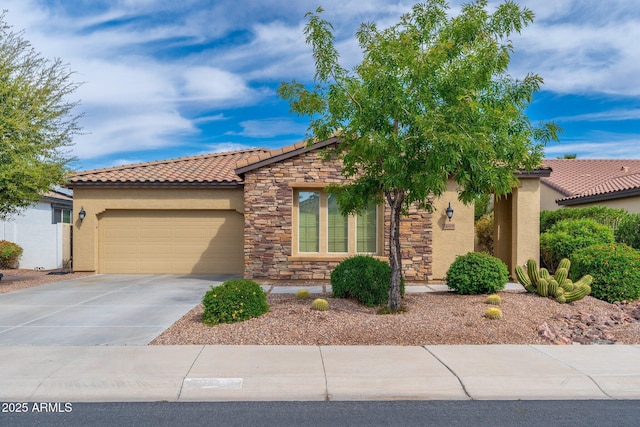 view of front facade featuring a tiled roof, stucco siding, stone siding, an attached garage, and concrete driveway
