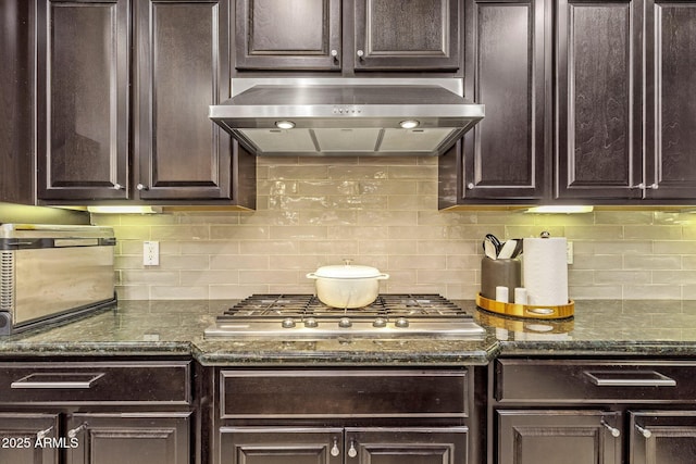 kitchen with dark brown cabinetry, exhaust hood, backsplash, and stainless steel gas stovetop