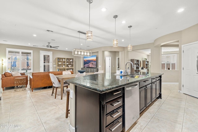 kitchen with light tile patterned floors, an island with sink, recessed lighting, a sink, and open floor plan
