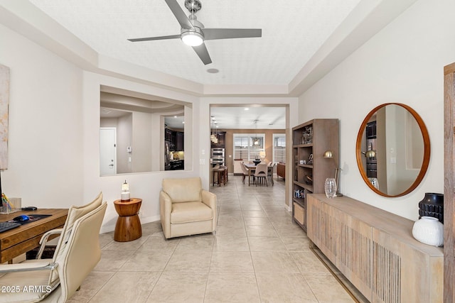 living room with light tile patterned floors, baseboards, and a ceiling fan