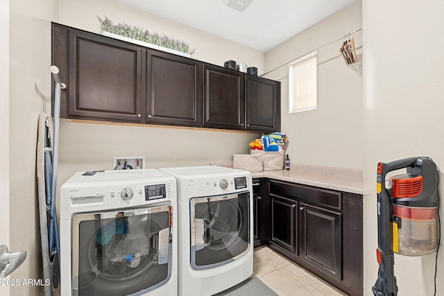 laundry area with visible vents, washer and clothes dryer, light tile patterned flooring, and cabinet space