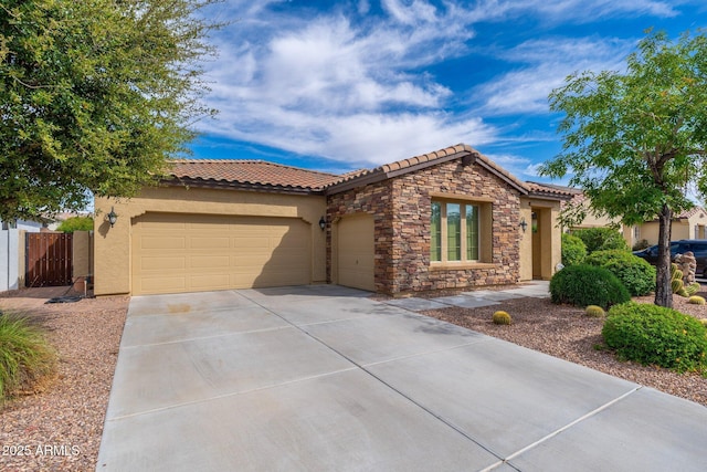 view of front of home featuring a tiled roof, stucco siding, fence, a garage, and concrete driveway