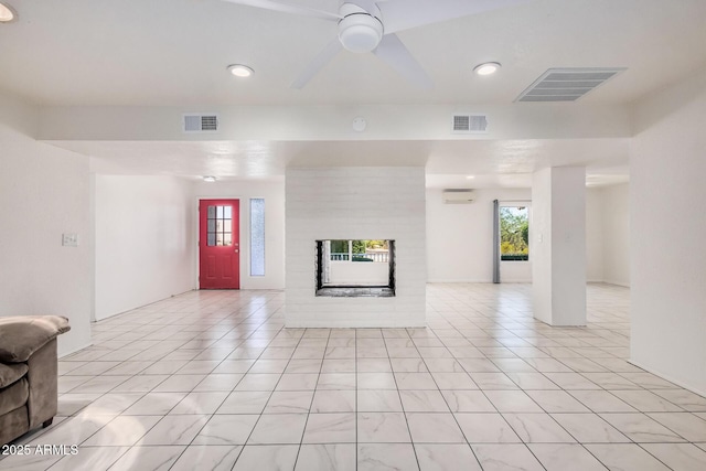 unfurnished living room featuring plenty of natural light, a brick fireplace, and visible vents