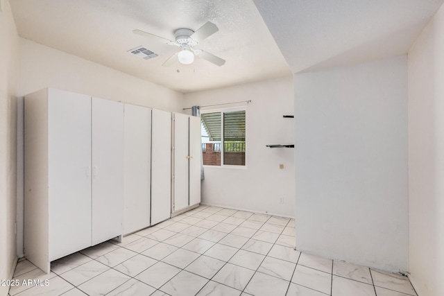 unfurnished bedroom with a ceiling fan and visible vents