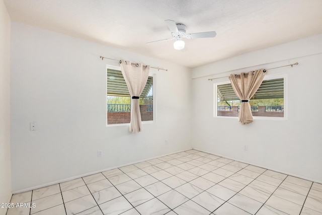 unfurnished room with a ceiling fan and plenty of natural light