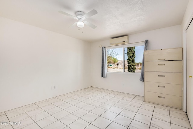 spare room featuring a ceiling fan, a textured ceiling, and a wall unit AC
