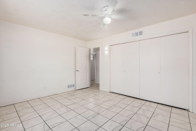 unfurnished bedroom featuring visible vents, a ceiling fan, and a closet