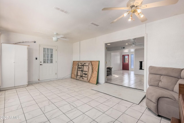 living area with ceiling fan and visible vents