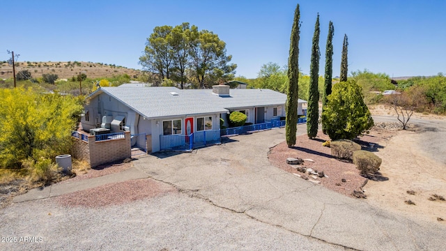 ranch-style home featuring a gate, a fenced front yard, and driveway