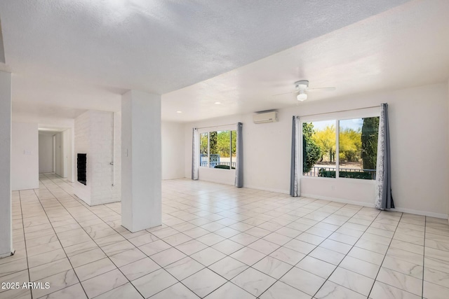 empty room featuring a fireplace, a textured ceiling, a wall unit AC, a ceiling fan, and light tile patterned floors