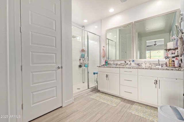 bathroom featuring vanity, an enclosed shower, and ceiling fan