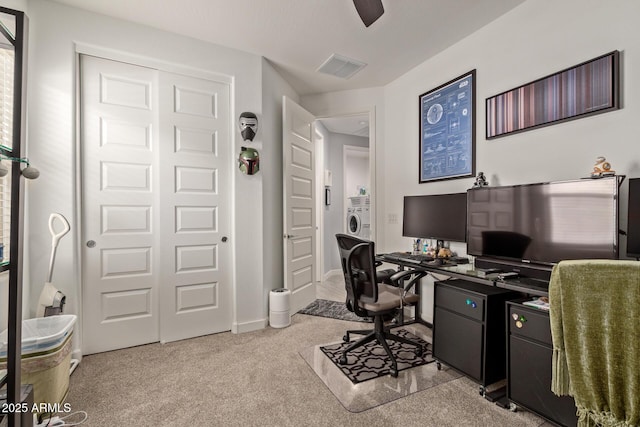 office space featuring ceiling fan, light colored carpet, and washer / dryer