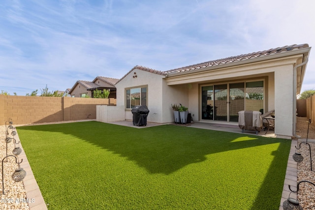 back of property with a patio area and a lawn