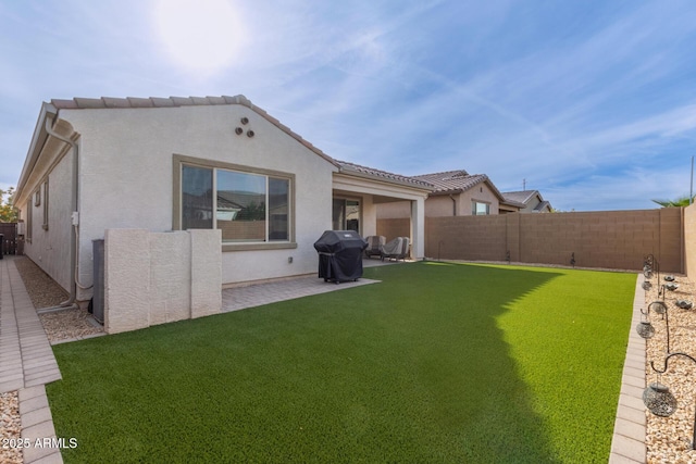 rear view of property featuring a lawn and a patio area