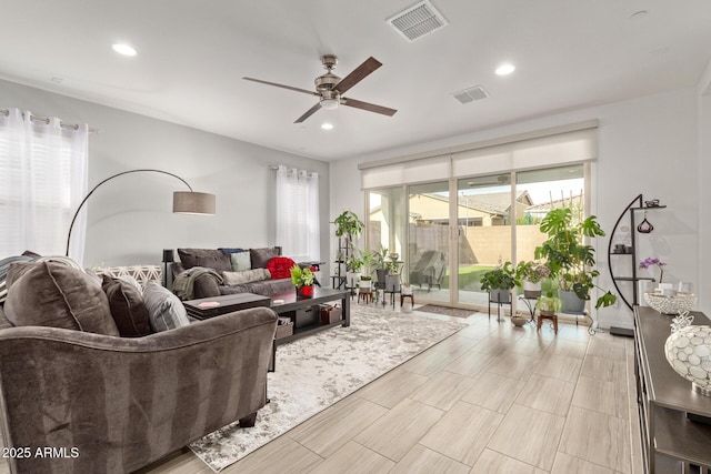 living room featuring ceiling fan and a healthy amount of sunlight