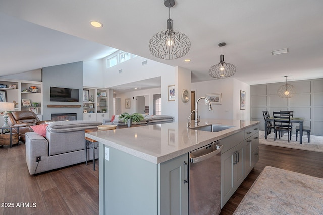 kitchen featuring a sink, a glass covered fireplace, dark wood finished floors, open floor plan, and stainless steel dishwasher