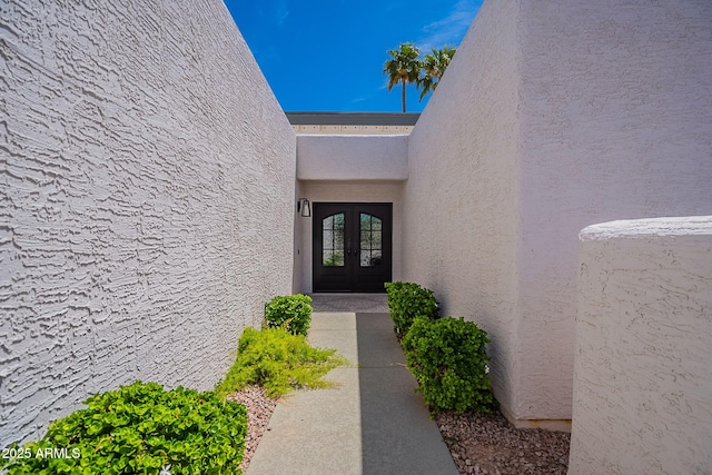 view of exterior entry with stucco siding and french doors