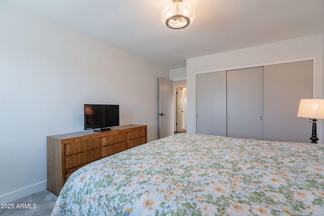 bedroom with baseboards, carpet, and a closet