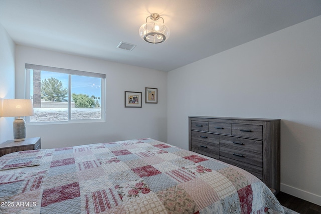 bedroom with dark wood-style flooring, baseboards, and visible vents