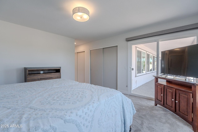 bedroom with light colored carpet, multiple closets, and access to exterior