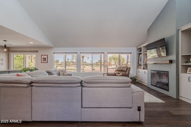 living area featuring a glass covered fireplace, high vaulted ceiling, recessed lighting, and dark wood-type flooring