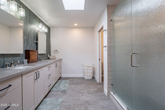 bathroom featuring baseboards, a sink, stone finish floor, and a shower stall