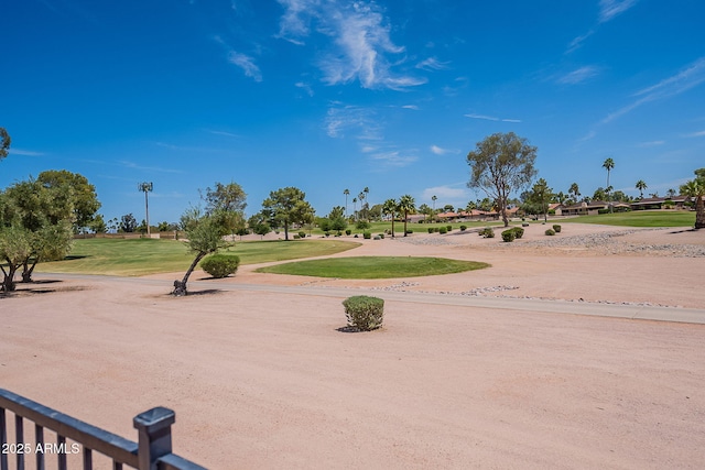 view of community featuring view of golf course and a yard