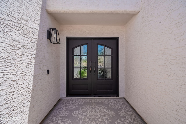 property entrance featuring french doors and stucco siding