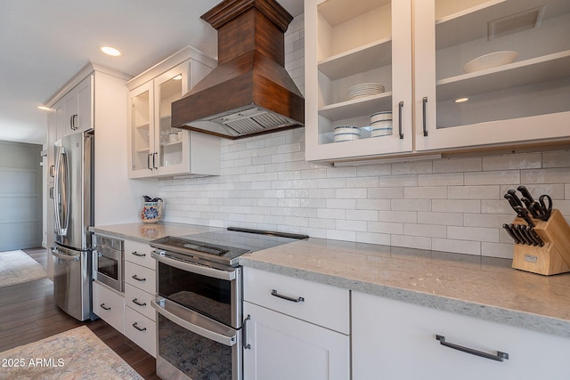 kitchen with visible vents, appliances with stainless steel finishes, light stone counters, custom exhaust hood, and dark wood-type flooring