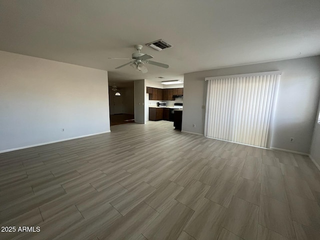 unfurnished living room with baseboards, wood finish floors, visible vents, and a ceiling fan