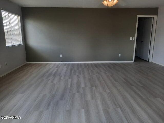 unfurnished room with wood finished floors and baseboards