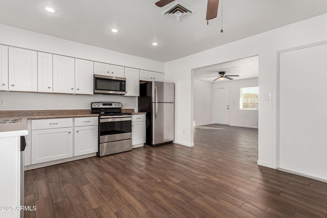 kitchen featuring dark hardwood / wood-style flooring, appliances with stainless steel finishes, white cabinets, and ceiling fan