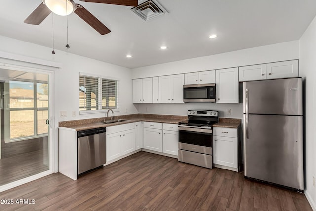 kitchen with sink, ceiling fan, appliances with stainless steel finishes, white cabinets, and dark hardwood / wood-style flooring