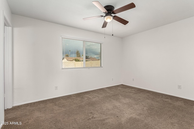 spare room with dark colored carpet and ceiling fan