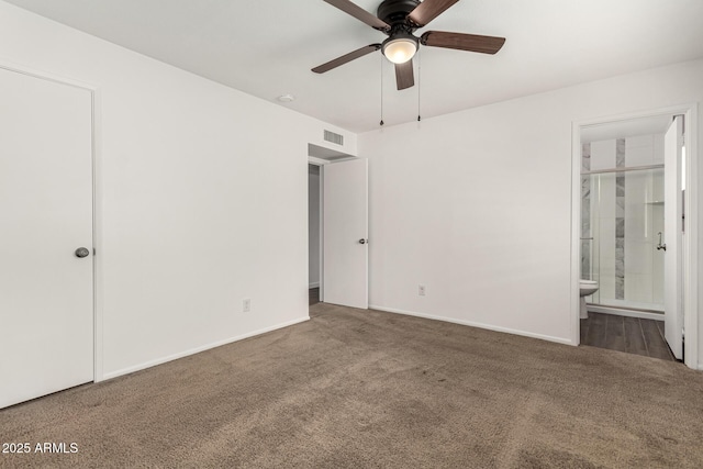 unfurnished bedroom featuring ensuite bathroom and dark colored carpet