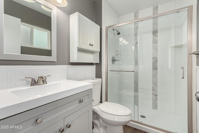 bathroom with vanity, a shower with shower door, and toilet